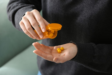 Woman holding container with pills, closeup