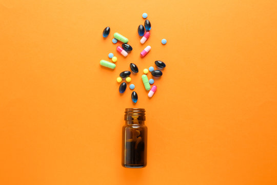 Glass Bottle With Pills On Color Background