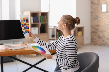 Beautiful young designer working in office
