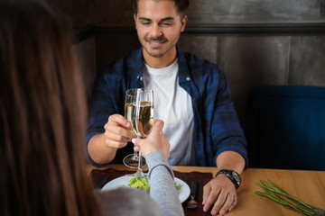 Loving couple with glasses of champagne in restaurant on romantic date