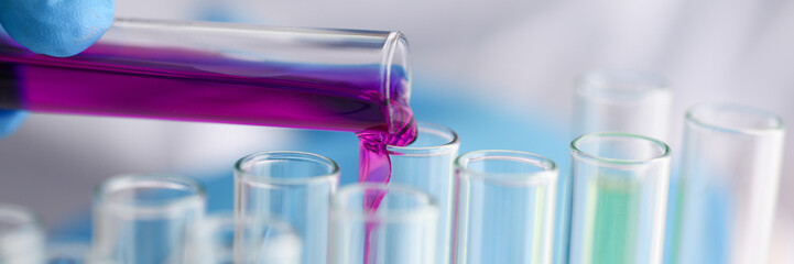 Male chemist holds test tube of glass in hi