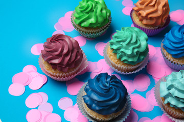 Different cupcakes on color background