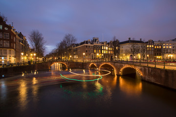 Fototapeta premium View on romantic canal Leidsegracht in Amsterdam at night with city lights, bridges and reflection on water
