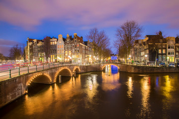 Obraz premium View on romantic canal Leidsegracht in Amsterdam at night with city lights, bridges and reflection on water