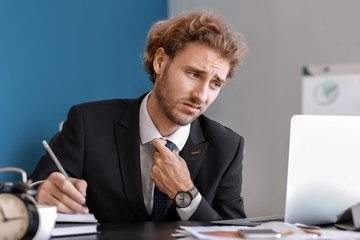 Stressed businessman trying to meet deadline in office