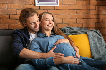 Young pregnant woman with her husband at home