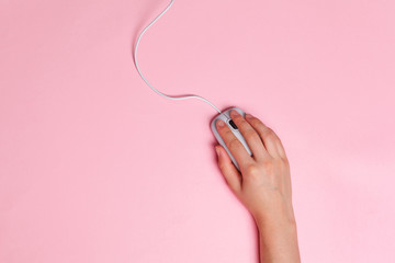 Woman's hands on a pink office workspace view from above