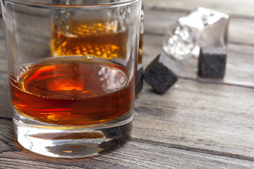 Whiskey beverage in glass with stone. Alcohol background