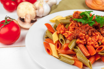 Pasta with meat, tomato sauce and vegetables on the table