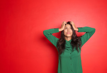 Naklejka premium Stressed young woman on color background