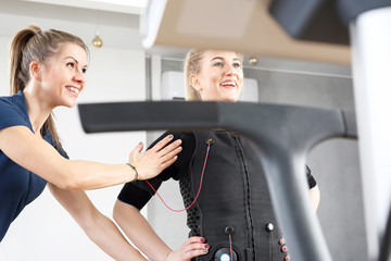 Trening personalny elektrostymulacja mięśni. Kobieta ćwiczy w specjalnym stroju do stymulacji mięśni. - obrazy, fototapety, plakaty