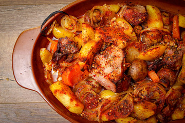Stew with homemade smoked meat and vegetables in ceramic bowl. Sweet and plain potato, carrot, champignon mushrooms garlic and onion.