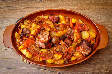 Stew with homemade smoked meat and vegetables in ceramic bowl. Sweet and plain potato, carrot, champignon mushrooms garlic and onion.