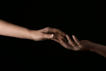 Obraz na płótnie Canvas Female hands touching fingers on dark background