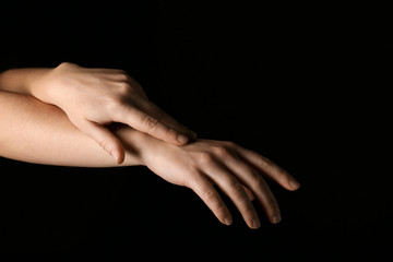 Female hands on dark background