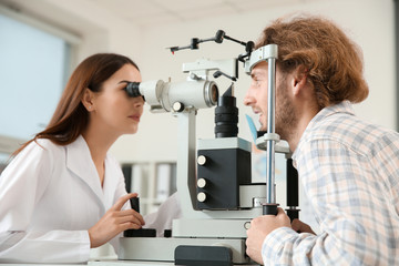 Ophthalmologist examining young man in clinic