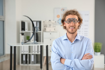 Young man with trial frames in ophthalmologist clinic