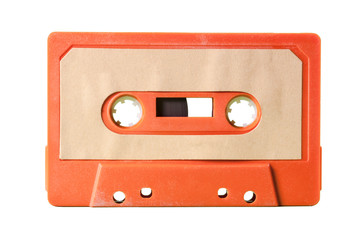 Obraz premium An old vintage cassette tape from the 1980s (obsolete music technology). Vivid colors: dark orange plastic body, sand pale pink label. 