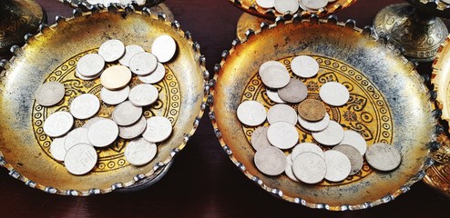 Many coins on old tray for donation or give at Thai temple. Faith or Belief of Buddhist people and Religion concept