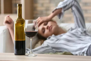 Gordijnen Glas en fles wijn op tafel van dronken vrouw © Pixel-Shot