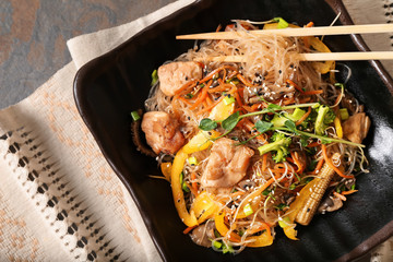Plate with tasty Chinese noodles on table
