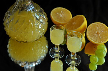 Vodka lemons in glasses and a carafe on a black background