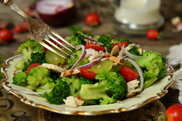Salad with chicken and broccoli on a rustic plate