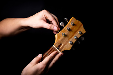 Strojenie gitary akustycznej.  Mężczyzna stroi instrument.