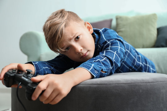 Cute Boy Playing Video Game At Home