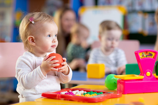 Cute little child playing with toys in nursery