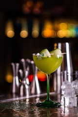 Alcoholic cocktail of green color on a bar counter. Cucumber cocktail