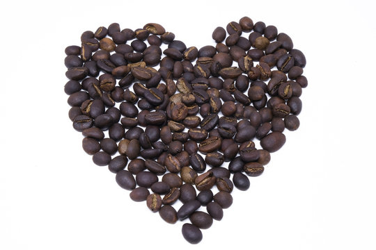 Heart shape draw by coffee beans. Royalty high-quality free stock macro photo image shape heart love design text by roasted black coffee bean on white background. Close-up or macro photo coffee beans