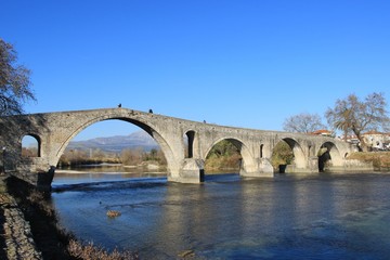 Fototapeta na wymiar Old famous stone bridge at the city of Arta at the banks of Arachthos river in Epirus Greece