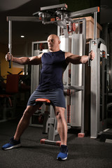 Fototapeta premium Muscular man training in gym