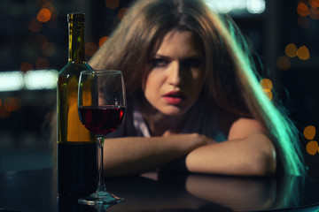 Young woman drinking alcohol in bar