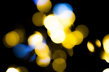 Fototapeta premium Abstract blurred yellow circles on dark background.