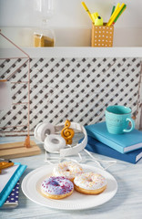 Plate with tasty doughnuts on white wooden table