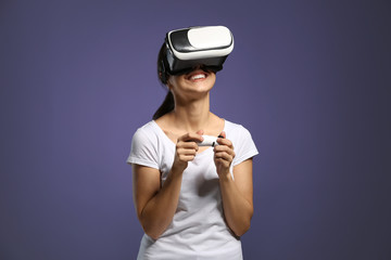 Young woman with virtual reality glasses on color background