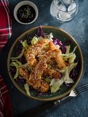 Salad with warm glazing chicken, sprinkled with sesame seeds. Chinese cuisine. Asian culture