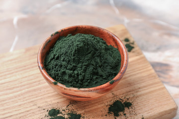 Bowl with spirulina powder on table