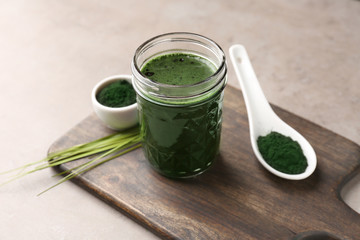 Glass with spirulina drink on table