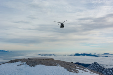 Fototapeta na wymiar Mountain rescue helicopter landing to pick up wounded.