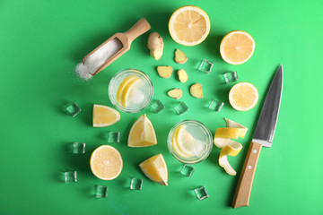 Fototapeta na wymiar Glasses of tasty cold lemonade with ingredients on color background