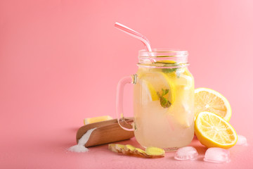 Obraz na płótnie Canvas Mason jar of tasty cold lemonade on color background