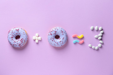 Composition with tasty candies and doughnuts on color background