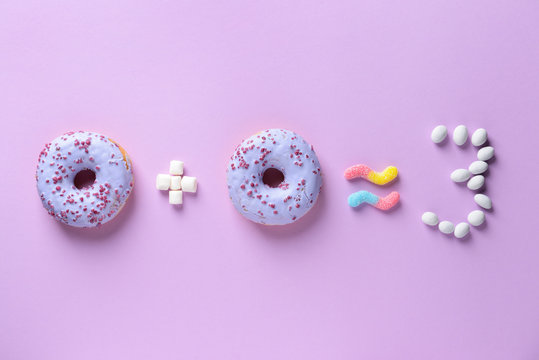 Composition with tasty candies and doughnuts on color background