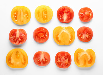 Cut tomatoes on white background, flat lay