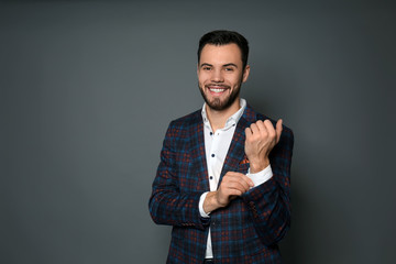 Fashionable young man in formal clothes on grey background