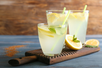 Glasses of fresh lemonade on wooden table