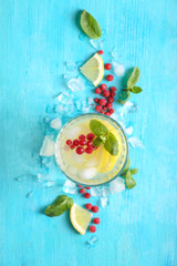 Glass of fresh lemonade on color background